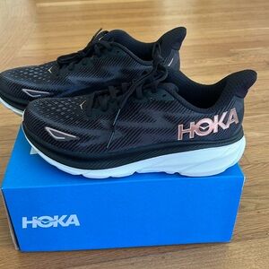 Brand new HOKA Clifton sneakers — Women, size 9B. Black with rose gold accents.